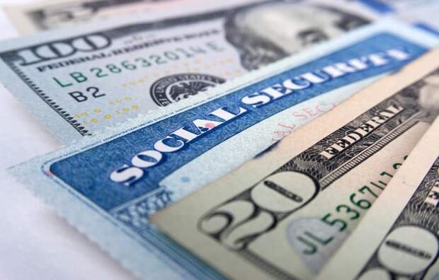 A Social Security card wedged between a fanned assortment of cash bills.