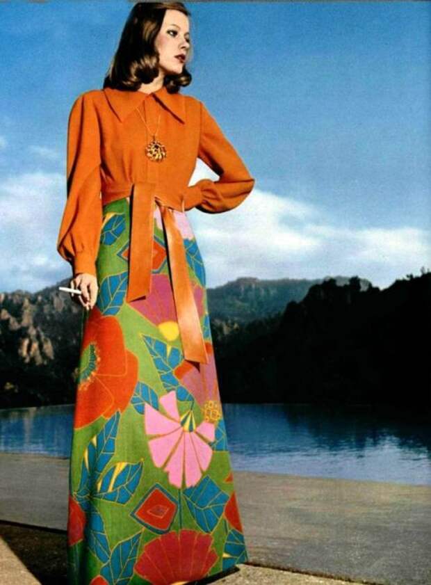Фасон платья женщины сочетается с яркой расцветкой сочного тона.
