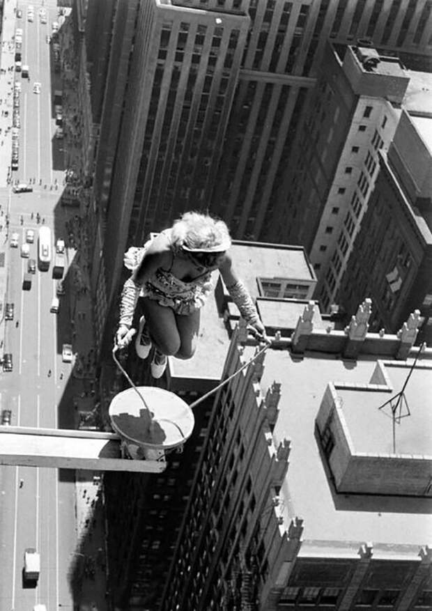 Акробатка Sky Dancer Бетти Фокс прыгает через скакалку на небольшой платформе высоко над улицами центра Чикаго. Иллинойс, 1955 год
