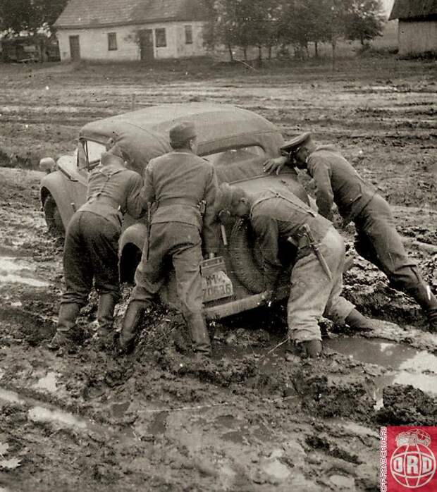 Четыре человека вытаскивают малолитражку Opel Kadett. Приличных дорог не было даже в населенных пунктах