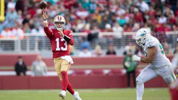 brock purdy throwing a football in a game against the dolphins