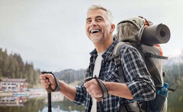 A smiling person backpacking.