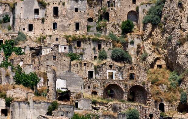 Каменные здания в цвет природного тона скалы, на которой они расположены, вызывают ощущение, что это пещеры, а не архитектурные сооружения (город-призрак Крако, Италия). | Фото: sergejsvarf.livejournal.com.