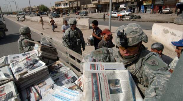 Специалист группы Психологических операций армии США раздает пропагандистские газеты на арабском языке местному населению
