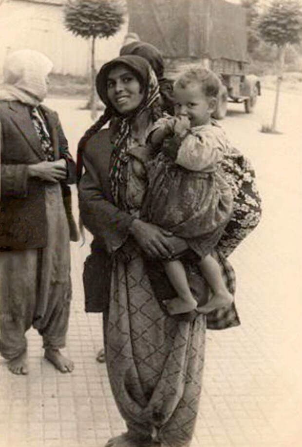 Фотография греческой цыганки со светловолосым ребёнком на руках середины двадцатого века.