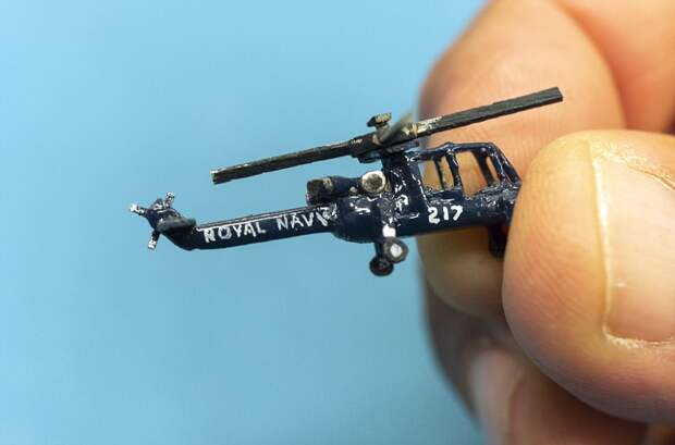 Philip holds a 1/300th scale Royal Navy helicopter, one of the many items in his extensive matchstick fleet