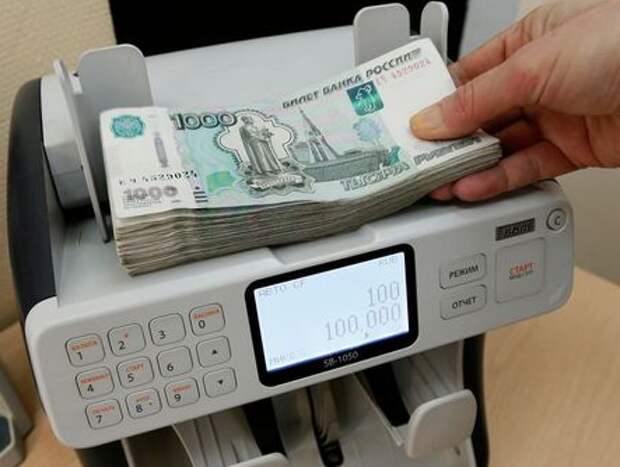 A cashier of a private company, which specializes in the wholesale trade of sweets and confectionery products, uses a machine while counting 1000 rouble banknotes at an office in Krasnoyarsk, Russia, January 22, 2016. The rouble maintained its slide through record lows on January 21, threatening more hardship for ordinary Russians and prompting some to stock up on dollars as the Kremlin denied the currency was collapsing. REUTERS/Ilya Naymushin