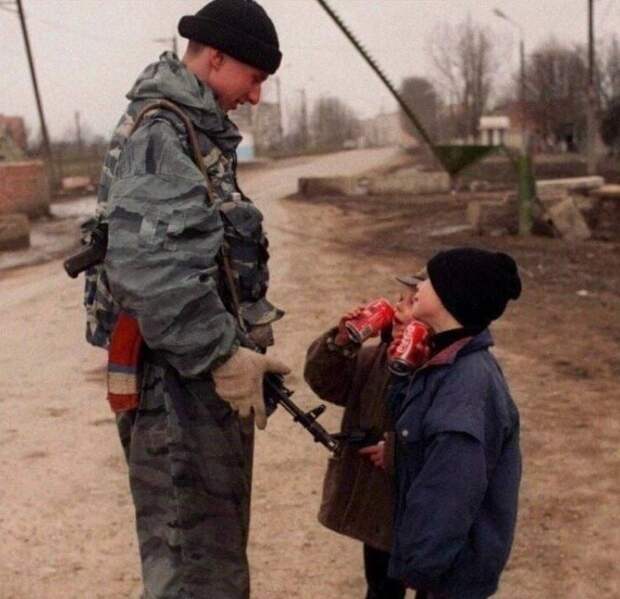Солдат федеральных сил угощает чеченских ребят кока-колой. 1996 год Солдат федеральных сил угощает чеченских ребят кока-колой. 1996 год