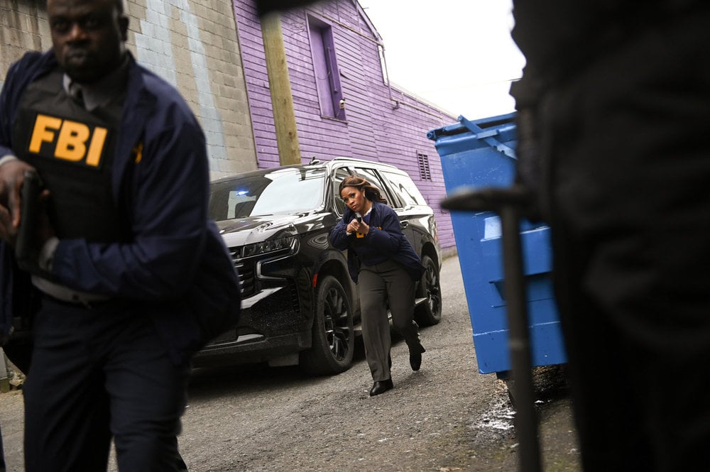 Marisa with her gun out by a black SUV on The Irrational Season 2 Episode 1