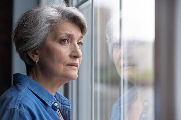 Stressed person looking out a window.