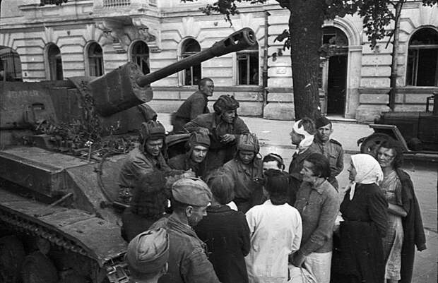 Экипаж советской САУ СУ-76М и пехотинцы общаются с жителями освобожденного советского города. Великая Отечественная Война, СССР, военная техника, германия