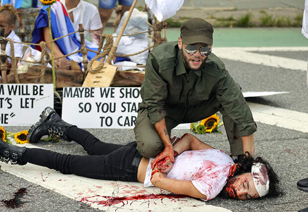 На фото: группа молодых людей из фонда «Художники вносят изменения» провела акцию, демонстрирующую военную тактику Кубы, чтобы остановить народ от протестов. Лос-Анджелес, США.