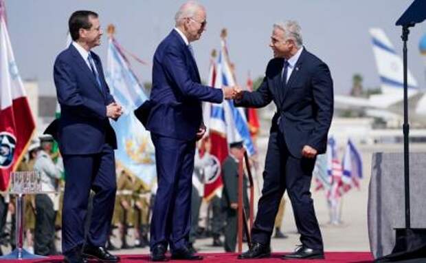 На фото: президент Джо Байден ударяет кулаками премьер-министра Израиля Яира Лапида (справа) после прибытия в аэропорт Бен-Гурион, в Тель-Авиве, а президент Исаак Херцог (слева) наблюдает за этим