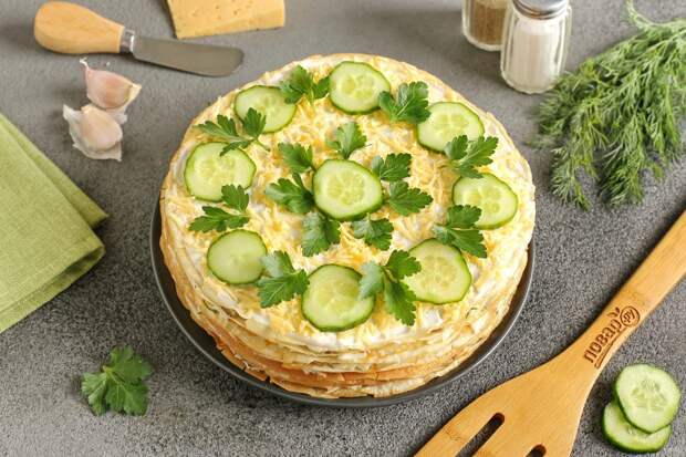 Блинный торт со шпротами готов. Украшаем закуску по вкусу. Я смазала верхний слой майонезом, посыпала тертым сыром, украсила зеленью и кружочками свежего огурца. Приятного аппетита!