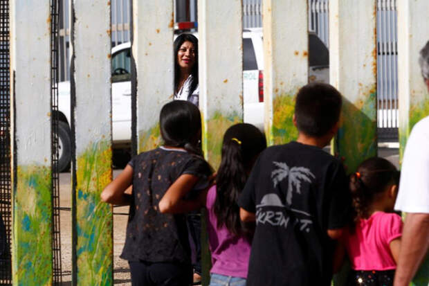 Женщина разговаривает с детьми в Парке дружбы, одна часть которого находится в американском городе Сан-Диего, а другая — в мексиканском городе Тихуана. граница, мексика, сша