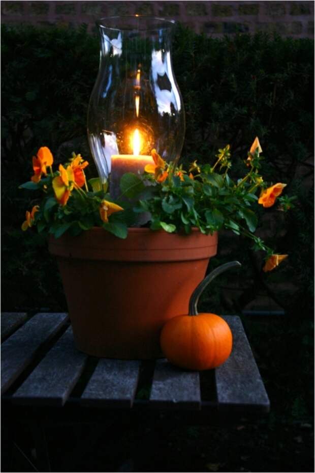 Горшок со свечой, создающий романтическую обстановку в саду. 