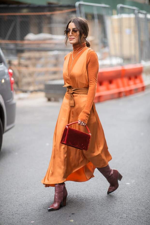 Девушка в оранжевом шелковом платье, водолазка и бордовые сапоги