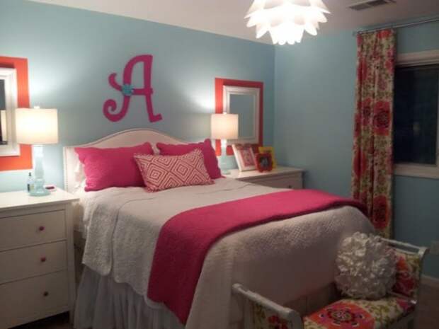 Ярко-розовая буква на стене перекликается с розовыми подушками и одеялом.