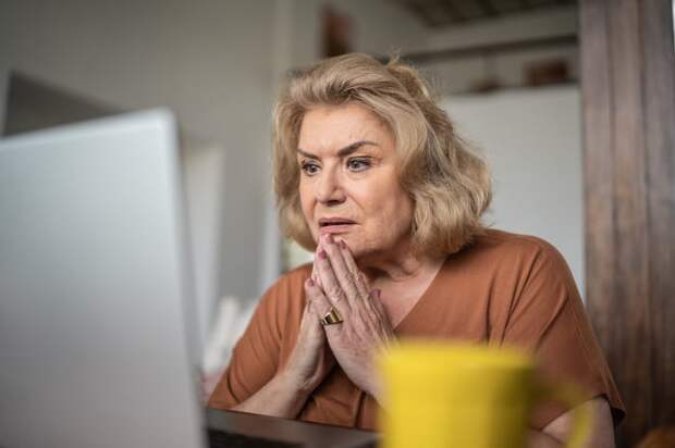 A person at a laptop looking distressed.