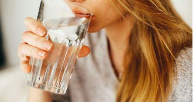 блондинка пьет воду из стакана