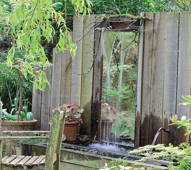 Зеркальный фрагмент забора выглядит оригинально и позволяет любоваться садом с неожиданного ракурса. Фото: MoySad.