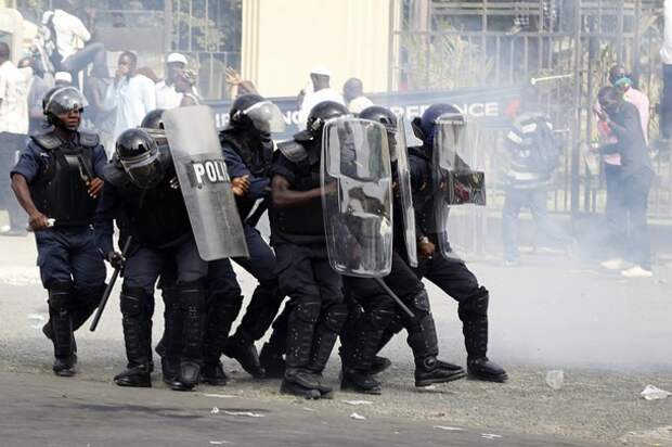 Riot police move through a cloud of tear gas towards protestors outside the National Assembly during a demonstration in Senegal's capital Dakar