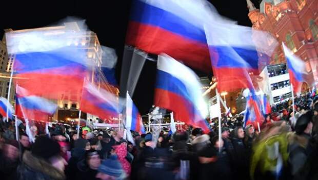 Люди с флагами России на Манежной площади. Архивное фото Люди с флагами России на Манежной площади. Архивное фото