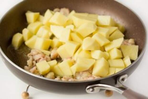 С куриного окорочка срезаем мясо, слегка обжариваем его вместе с кусочками картофеля на подсолнечном рафинированном масле.