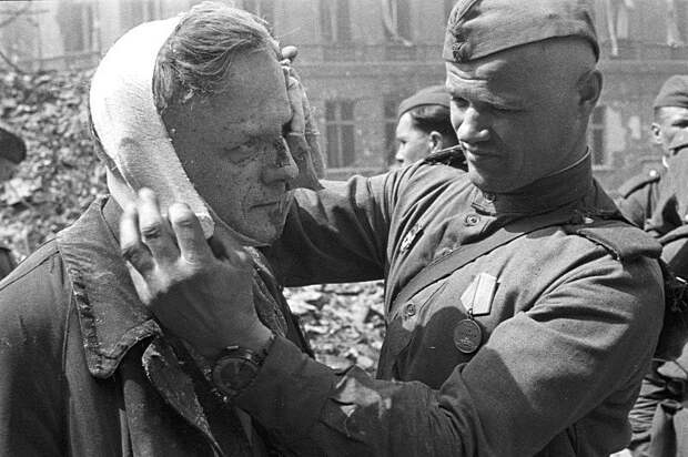 Советский солдат делает перевязку раненому берлинцу. Великая Отечественная война, СССР, Солдаты моей страны