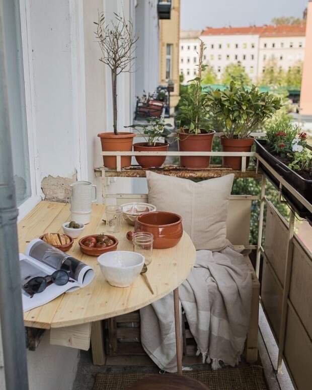 Маленький обшарпанный балкон — не помеха большим планам. Главное — желание сделать зону для отдыха. Здесь мы видим самодельный деревянный складной столик, журнал, посуду для завтрака и местечко с пледом для одного. Комфорт — в деталях