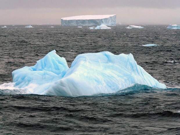 Маленький голубой айсберг и большой белый айсберг
