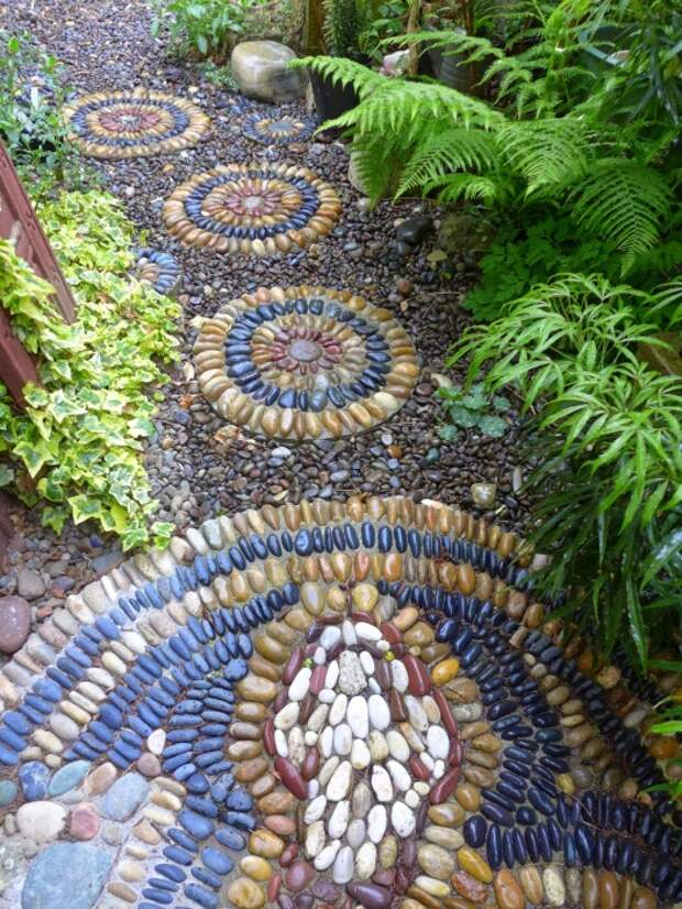 Мозаичное покрытие дорожек на садовом участке можно сделать из разбитых плиток или мелкой разноцветной гальки.