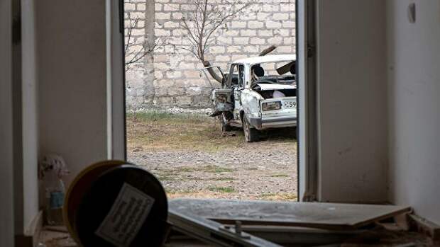 Поврежденный дом и автомобиль в результате обстрелов по общине Иванян Нагорного Карабаха