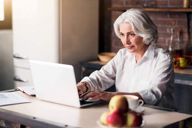 Someone sitting at a table and using a laptop.