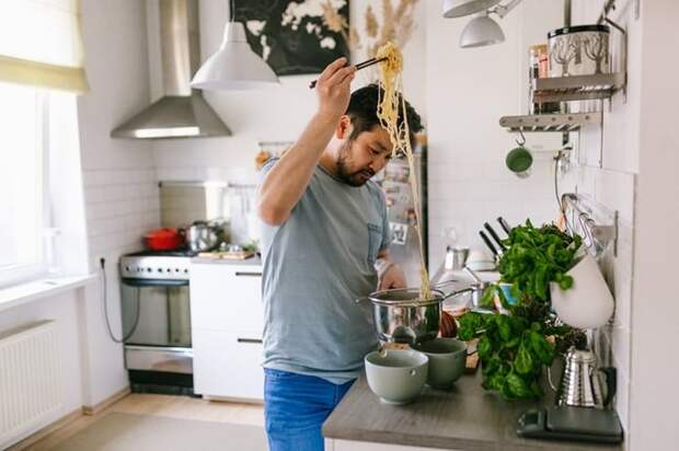 A man cooking pasta in his kitchen at home.