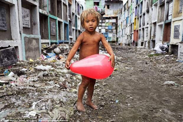 Портрет был сделан на кладбище в Маниле, Филиппины, где живет коммуна бездомных, включая и этого малыша. Он нашел среди костей воздушный шарик и теперь играет с ним в мире, дети, жизнь
