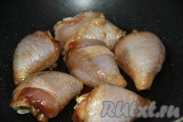 В глубокую сковороду влить немного масла и разогреть, выложить кусочки курицы. 
