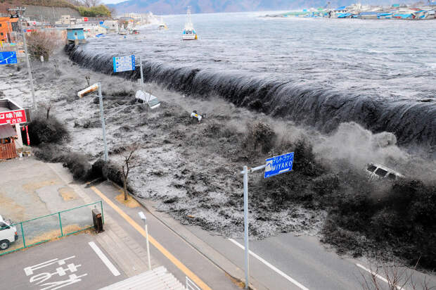 Волна переливается на улицу в Мияко в префектуре Иватэ