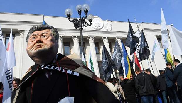 Участник акции протеста у здания Верховной рады в маске президента Украины Петра Порошенко