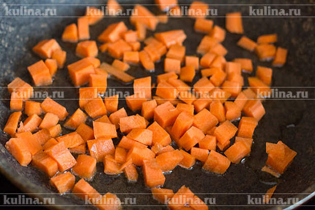 В сковороде разогреть растительное масло. Морковь нарезать кубиком, выложить в сковороду и слегка обжарить.
