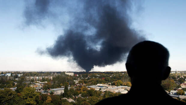 Житель города смотрит на дым над Донецком. Архивное фото