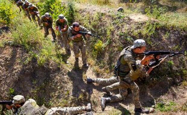 На фото: украинские военнослужащие идут гуськом по траншее