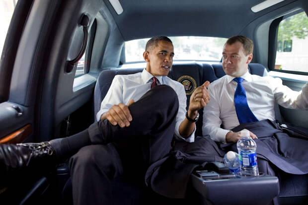 Обама о чем-то беседует с Медведевым, сидя на велюровом заднем диване президентского лимузина. Автомобиль главы США произведен компанией General Motors: выпущено 12 схожих бронированных машин на платформе грузового пикапа GMC TopKick