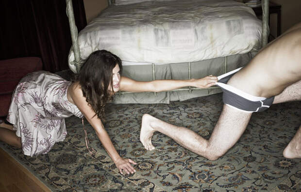 Young woman pulling underwear of young man