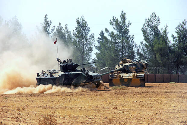 A Turkish army tank and an armored vehicle are stationed near the border with Syria, in Karkamis, Turkey, Tuesday, Aug. 23, 2016. Turkish media reports say Turkish artillery on Tuesday launched new strikes at Islamic State targets across the border in Syria, after two mortar rounds, believed to have been fired by the militants, hit the town of Karkamis, in Turkey's Gaziantep province. Hurriyet newspaper and other reports said the mortar rounds were fired from IS-held Jarablus, Syria.(IHA via AP)