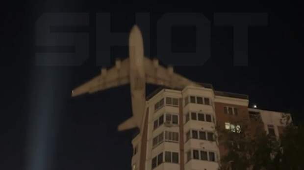 Самолет над крышами домов / Кадр из видео: Shot