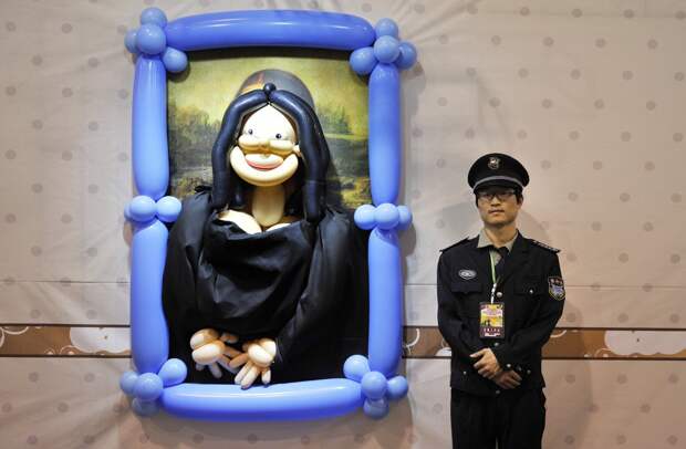 a-security-guard-stands-next-to-a-balloon-art-piece-depicting-mona-lisa-by-leonardo-da-vinci-at-a-balloon-themed-carnival-in-hefei-china
