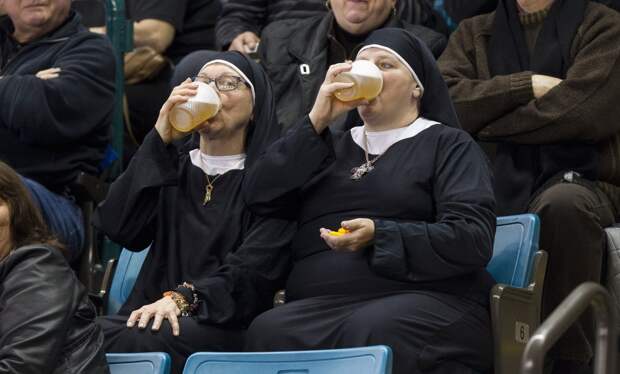 two-women-wearing-nun-outfits-drink-beer-while-watching-the-playoff-draw-between-quebec-and-manitoba-at-the-2014-tim-hortons-brier-curling-championships-in-canada-on-march-8
