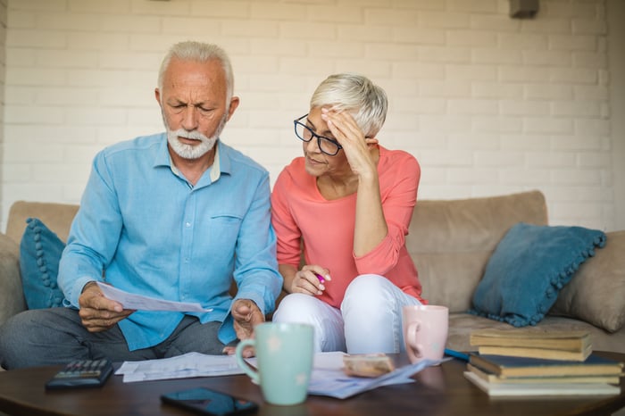 Two people with concerned expressions looking at paperwork.