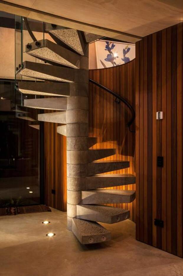 Компактная спиральная лестница с металлическими перилами и ступенями из гранита - настоящая изюминка в интерьере.